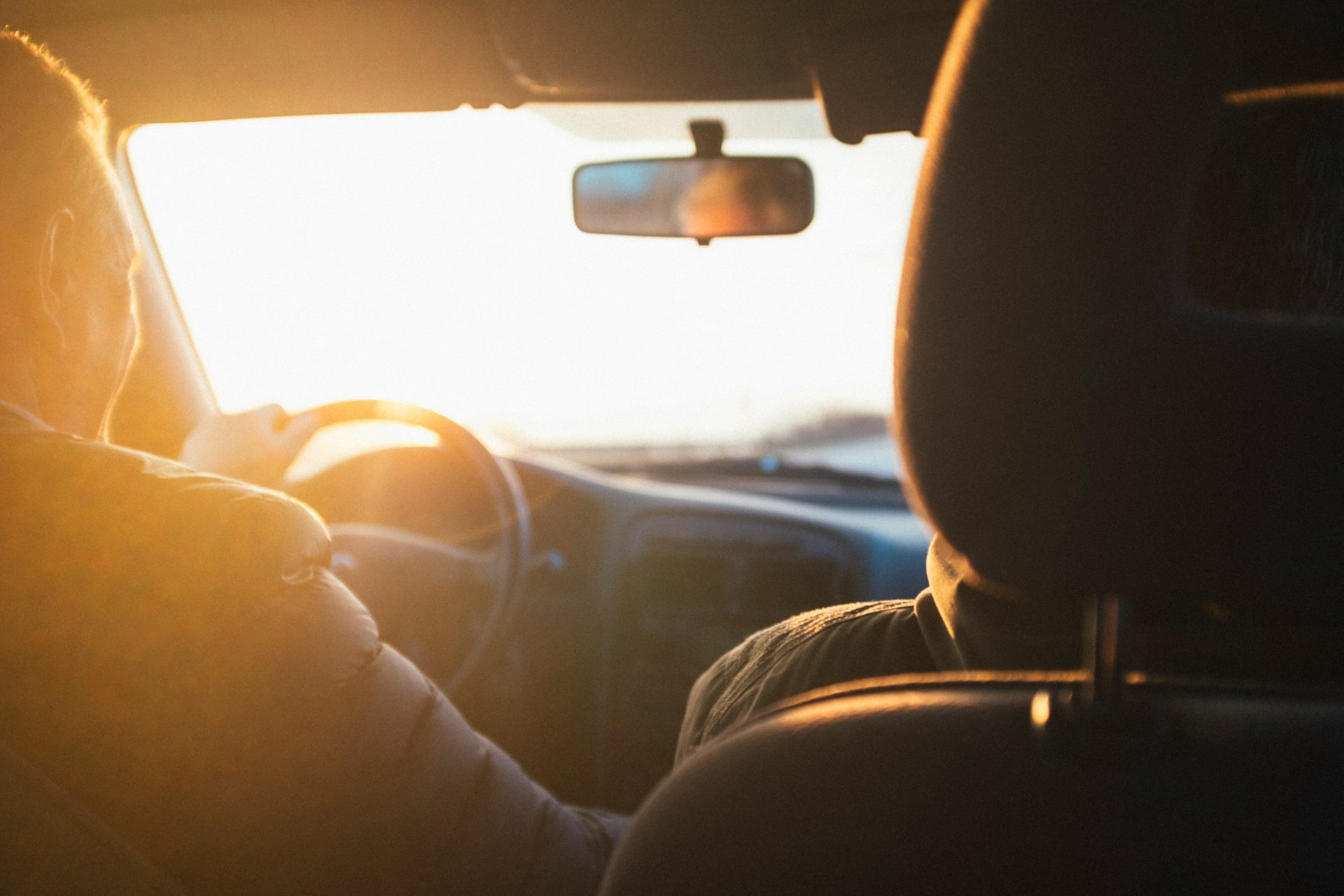 Hombre conduciendo un coche durante la hora dorada
